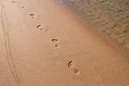 Footprints in the sand on a sunny beachの写真素材