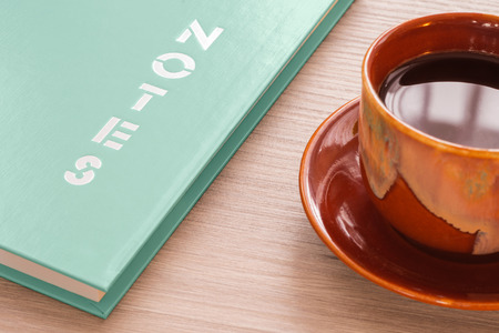 Coffee cup and notebook on wood deskの写真素材