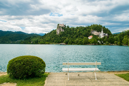 Bled castle with lake and white bench in foreground in Sloveniaのeditorial素材
