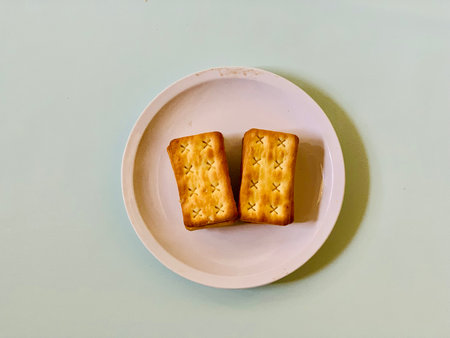 Biscuits on a white plate on a light blue background.