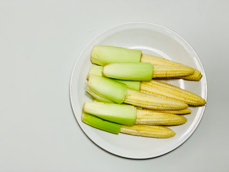 baby corn on white plate isolated on white background, top view.の写真素材