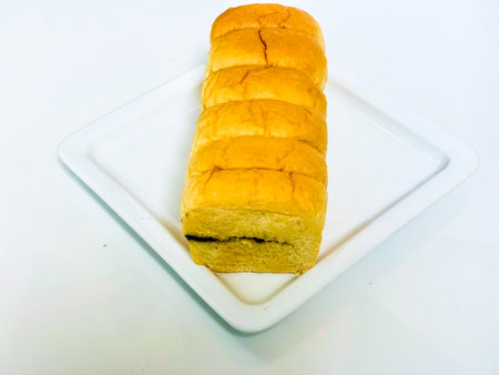 Loaf of bread on a white plate on a white background.の写真素材