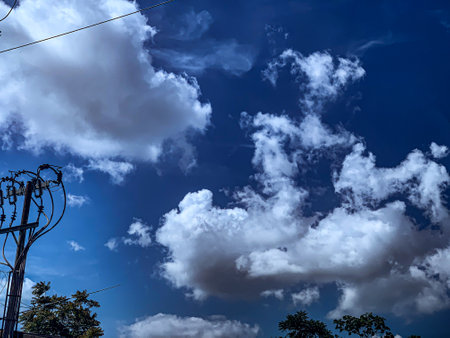 blue sky with white clouds and electricity pole in the city of Thailandの写真素材