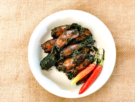 Fried pork with sweet and sour sauce in white dish on sackcloth background