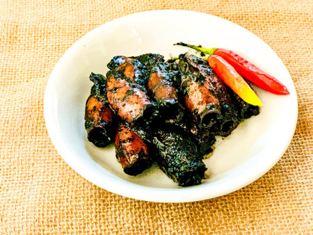 Thai style grilled pork with sweet and sour sauce on white plate.