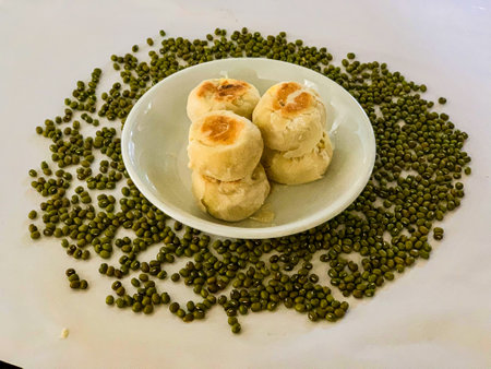 Mung bean cake on white dish with green beans background, Thailand.