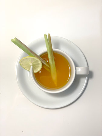 Cup of lemon tea with celery on a white background.の写真素材