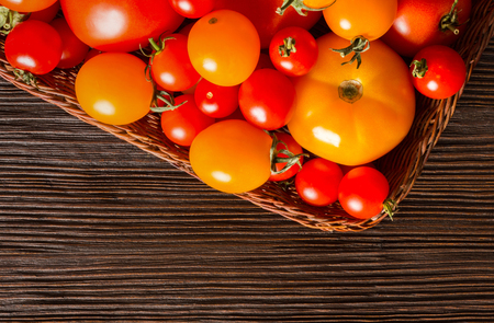 Different kinds of fresh tomatoes on grunge wooden surface, top viewの写真素材