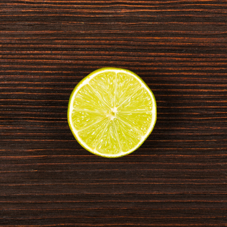 Fresh lime on dark wooden table, top viewの写真素材
