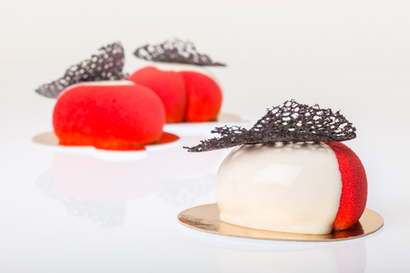 Group of french mousse cake covered with red and white glazeの写真素材