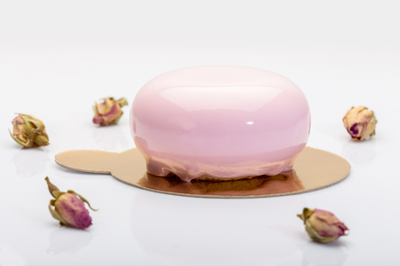 French mousse cake covered with pink glaze on white backgroundの写真素材