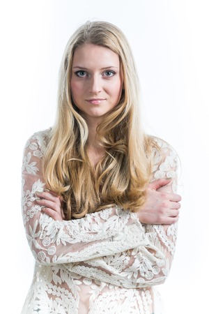 blonde girl on a white background in a white translucent blouseの写真素材