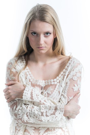 blonde girl on a white background in a white translucent blouseの写真素材