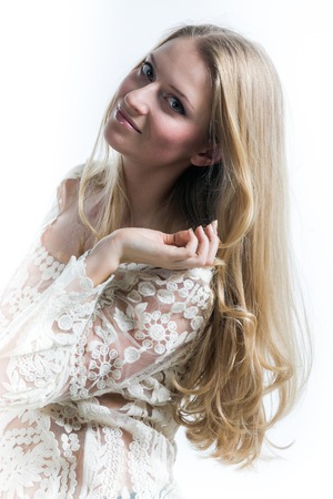 blonde girl on a white background in a white translucent blouseの写真素材