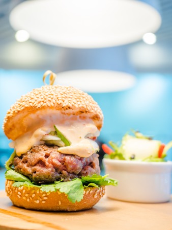 burger with a large chop and white sauceの写真素材