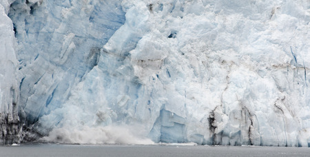 Ice falling from the glacier create quite a splash when they hit the water.の写真素材