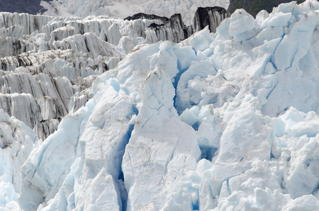 Pure whites and blue of clean ice are set against ice that carries some of the mountain to the sea.の写真素材