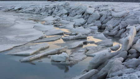 Tidal action has broken the ice up into sheets and pushed it up on to the shore
