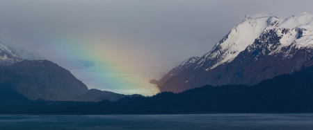 The end of a rainbow falls on Grewingk Glacier on the Kenaii Peninsula in Alaska.の写真素材