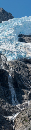 Water from a melting glacier cascades down the face of the mountain.の写真素材