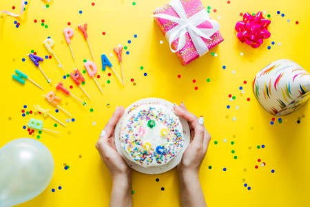 Happy Birthday day cupcake and cake bakery with candles, bright lights bokeh. Background holiday...