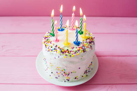 Happy Birthday day cupcake and cake bakery with candles, bright lights bokeh. Background holiday...