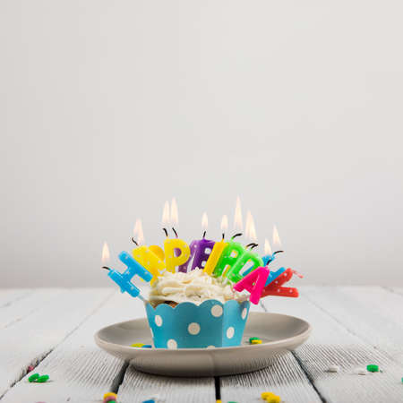 Happy Birthday day cupcake and cake bakery with candles, bright lights bokeh. Background holiday...