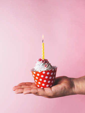 Happy Birthday day cupcake and cake bakery with candles, bright lights bokeh. Background holiday with confetti, balloon and place for text.の写真素材