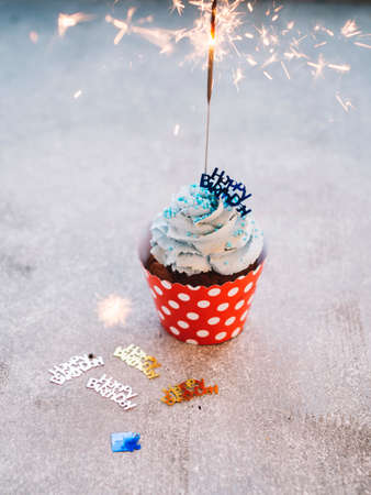 Happy Birthday day cupcake and cake bakery with candles, bright lights bokeh. Background holiday...