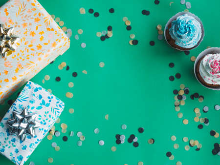 Happy Birthday day cupcake and cake bakery with candles, bright lights bokeh. Background holiday with confetti, balloon and place for text.の写真素材