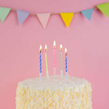 Happy Birthday day cupcake and cake bakery with candles, bright lights bokeh. Background holiday with confetti, balloon and place for text.の写真素材