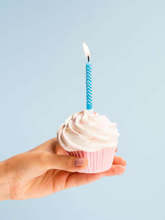 Happy birthday day cake or cupcake lies or hold on the hand. Holiday background with place for text.