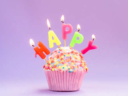 Happy birthday day cake or cupcake with candles and light. Background with place for text.
