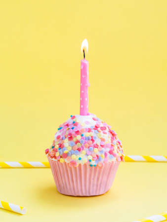 Happy birthday day cake or cupcake with candles and light. Background with place for text.の写真素材