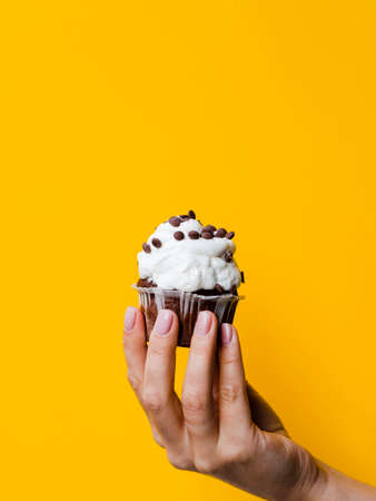 Hand hold cupcake isolated on a background, close-up. Happy birthday concept.の写真素材