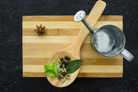 Various herbs spices with place for text isolated dark background, plate. Top view.