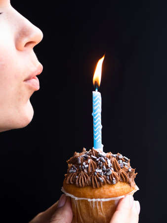 Birthday man puts out a candle on a cake or cupcake. Happy birthday concept.