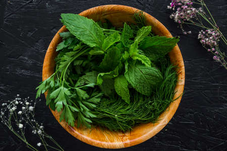 Various herbs spices with place for text isolated dark background, plate. Top view.