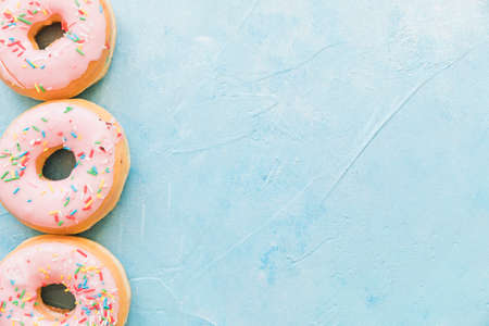 Abstract colorful donuts bakery, sweet concept background with place for text. Top view. Glazed...
