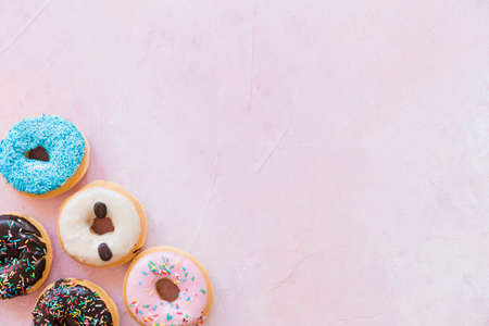 Abstract colorful donuts bakery, sweet concept background with place for text. Top view. Glazed...