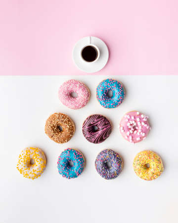 Colorful donuts with cup coffee, top view