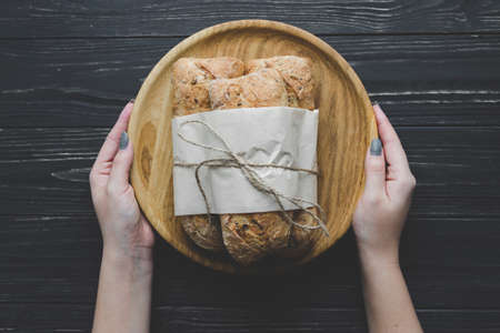 hands pack bread on a dark wooden backgroundの写真素材