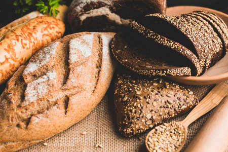 Different baking buns, croissants, gingerbread cookies. Delicious freshly baked bread on wooden...