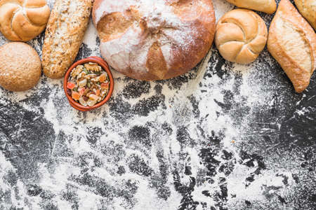 Different baking buns, croissants, gingerbread cookies. Delicious freshly baked bread on wooden background with place for text. Fresh loaves of bread And sliced ââbreads containing sesame seeds.の写真素材