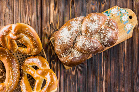 Different baking buns, croissants, gingerbread cookies. Delicious freshly baked bread on wooden background with place for text. Fresh loaves of bread And sliced ââbreads containing sesame seeds.の写真素材