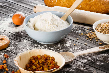 Flour and kitchen utensils whisk, baking dish, rolling pin with eggs on the table. Baking, cooking...