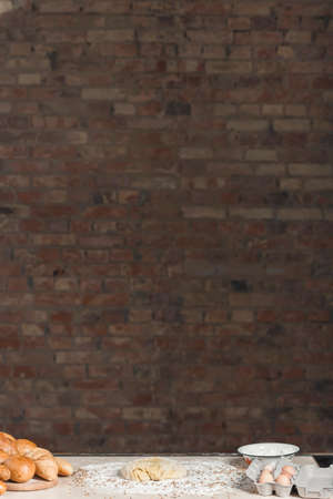bread and pastries lies on a table against a brick wall