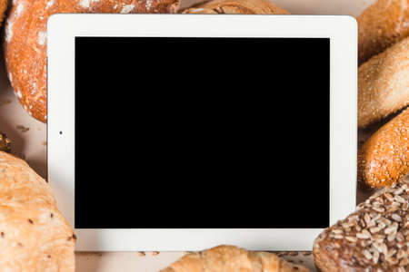 Blank screen digital tablet with bread. Mockupの写真素材