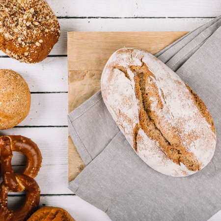 Different baking buns, croissants, gingerbread cookies. Delicious freshly baked bread on wooden background with place for text. Fresh loaves of bread And sliced ââbreads containing sesame seeds.の写真素材