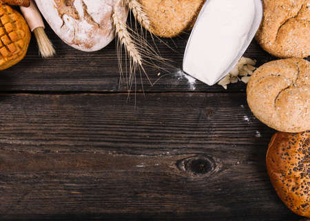 Different baking buns, croissants, gingerbread cookies. Delicious freshly baked bread on wooden...